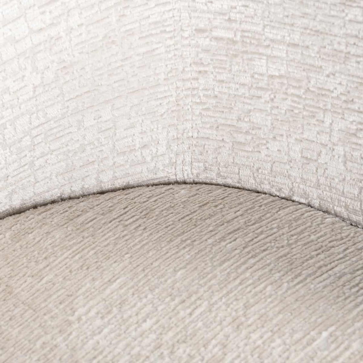 Close-up van een crème gekleurde eetkamerstoel met zachte stoftextuur.