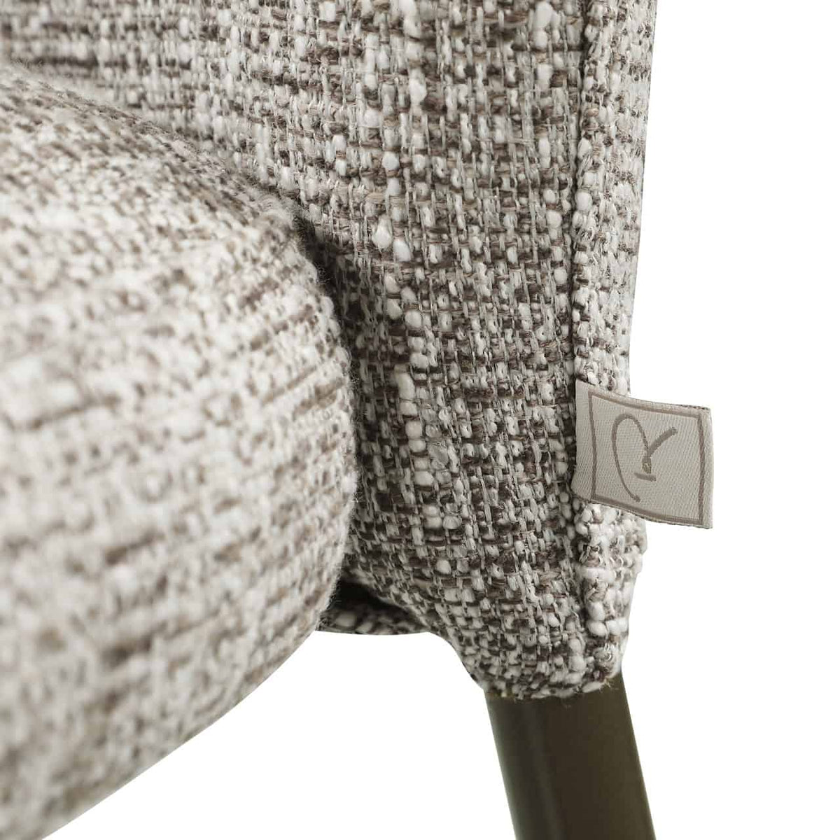 Dichtbijzicht van de gestoffeerde eetkamerstoel met earth tweed stof.
