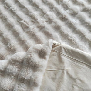 Zacht, wollig plaid in crème kleur voor gezellige interieurs.
