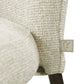 Dichtbijzicht van een beige eetkamerstoel met textuurrijke bekleding en houten poot.