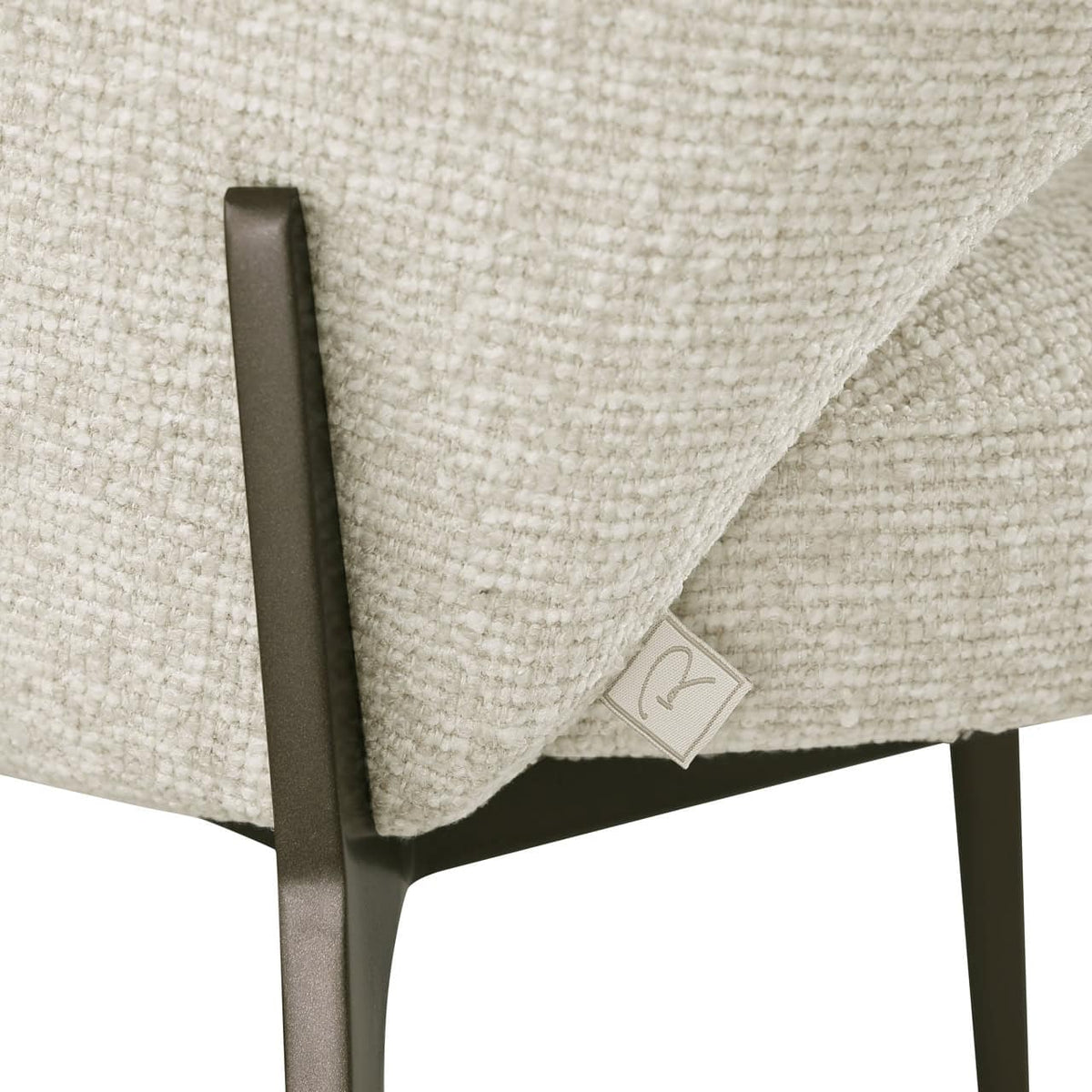 Close-up van de Kenzi biscotti eetkamerstoel met stoffen bekleding en zwart metalen poten.