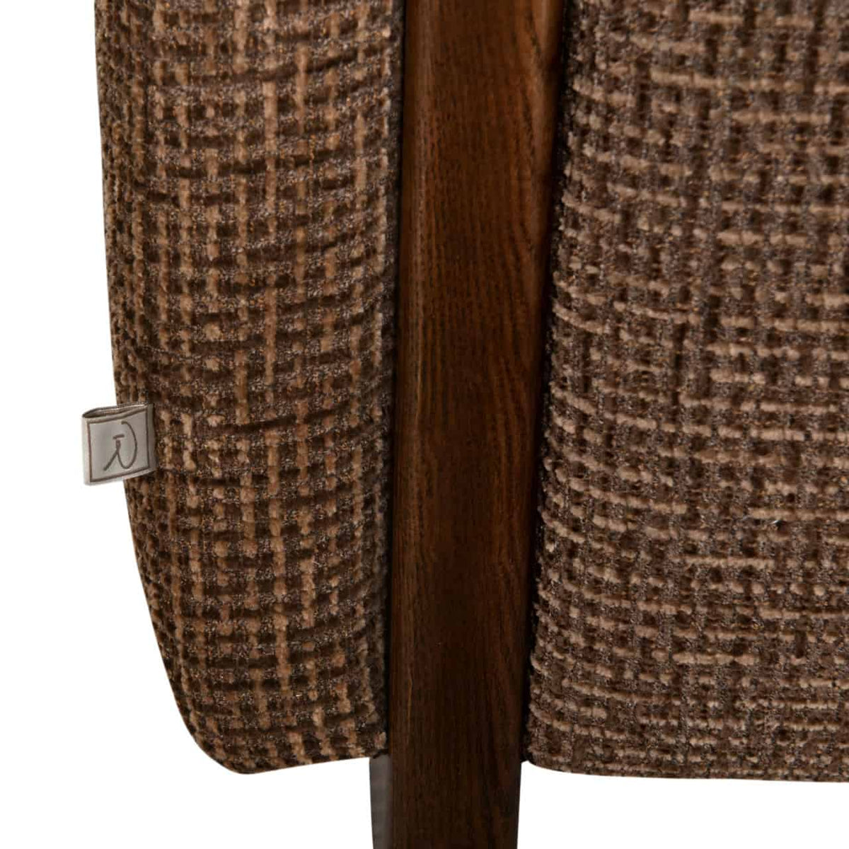 Close-up van een bank met bruin blokweefsel en houten poot.