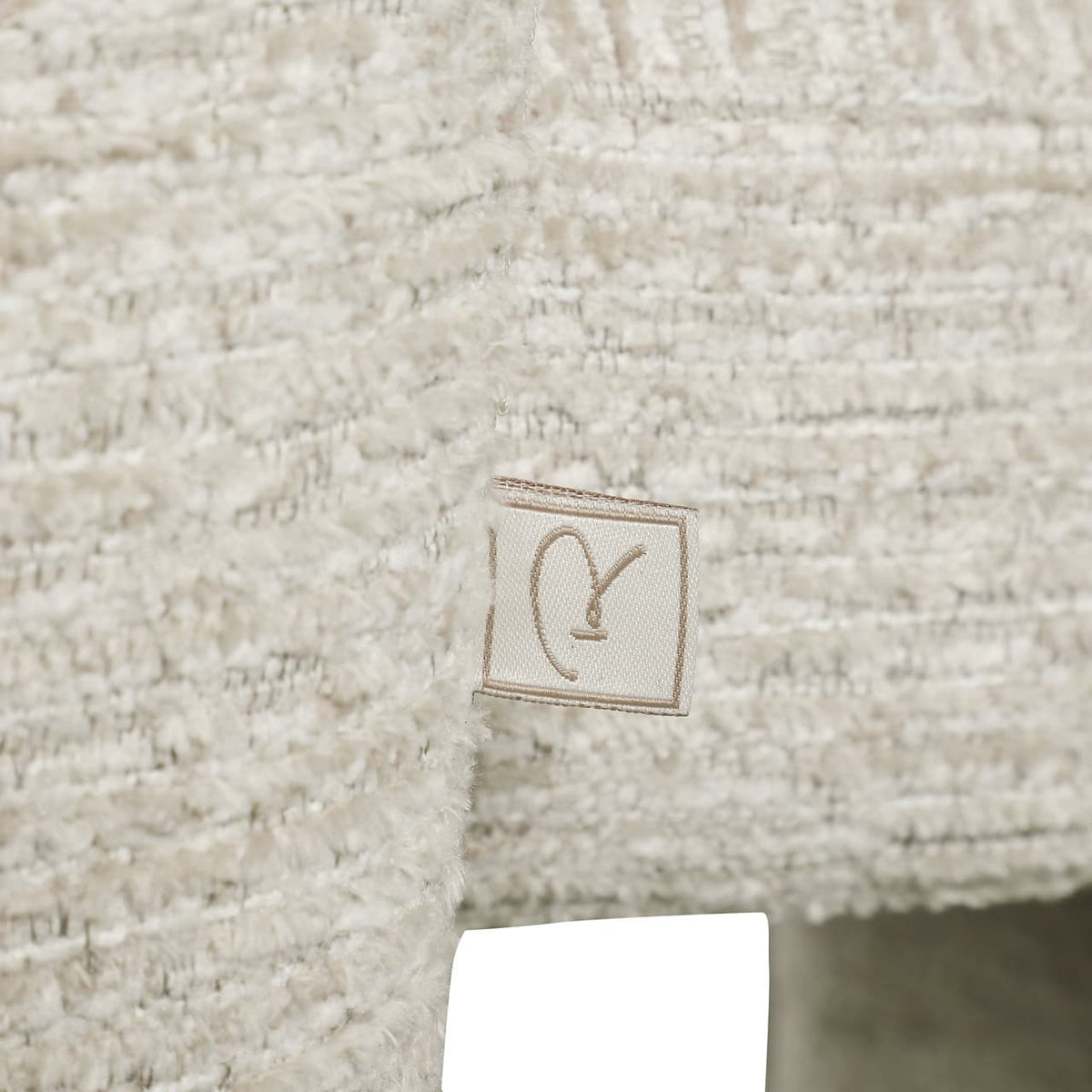 Close-up van een zachte, beige textuur met Richmond logo.