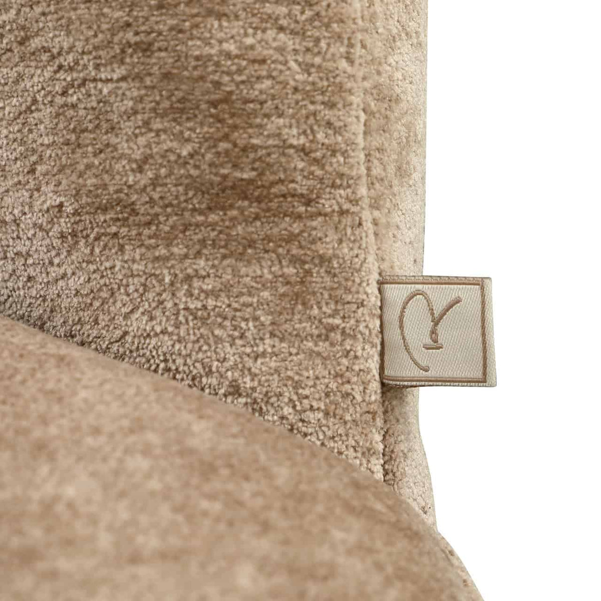 Dichte close-up van de zachte zandkleurige bekleding van de Cassi eetkamerstoel.